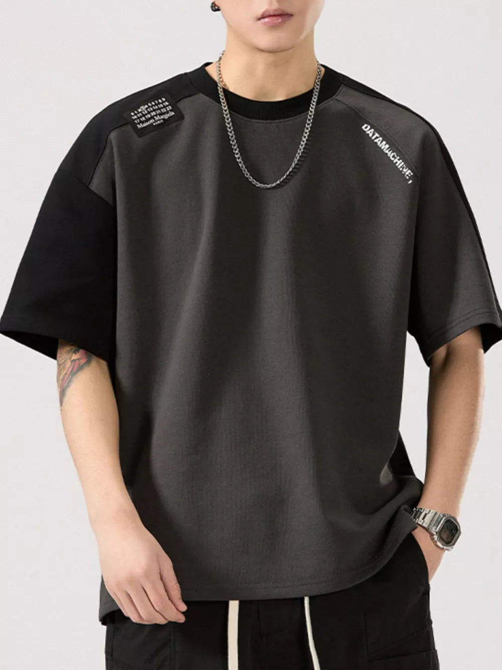 Modern color block t-shirt in gray with black sleeves, round neck, and graphic detail.