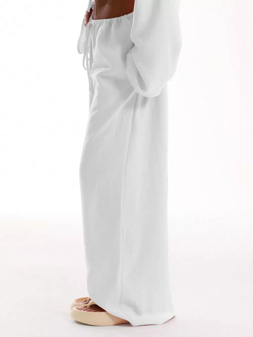 White relaxed wide-leg maternity pants with drawstring waist and pockets.
