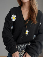 Black oversized knit cardigan with daisy embroidery and button front.