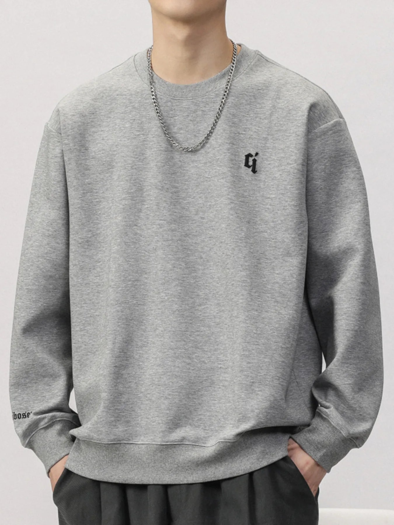 Plus-size gray cotton blend round-neck sweatshirt with embroidered logo and text detail.