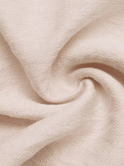 Luxe ruffled V-neck wide-leg romper in textured cream fabric.
