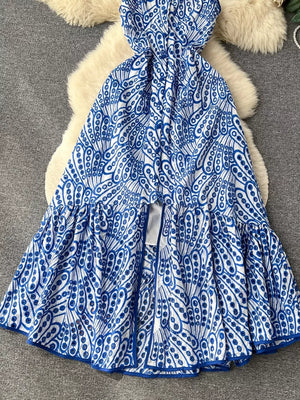 Blue and white lace-embroidered tiered cami dress with cutout detail and ruffled hem.