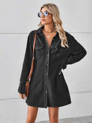 Black oversized denim shirt dress with button front, chest pockets, and cuffed sleeves.