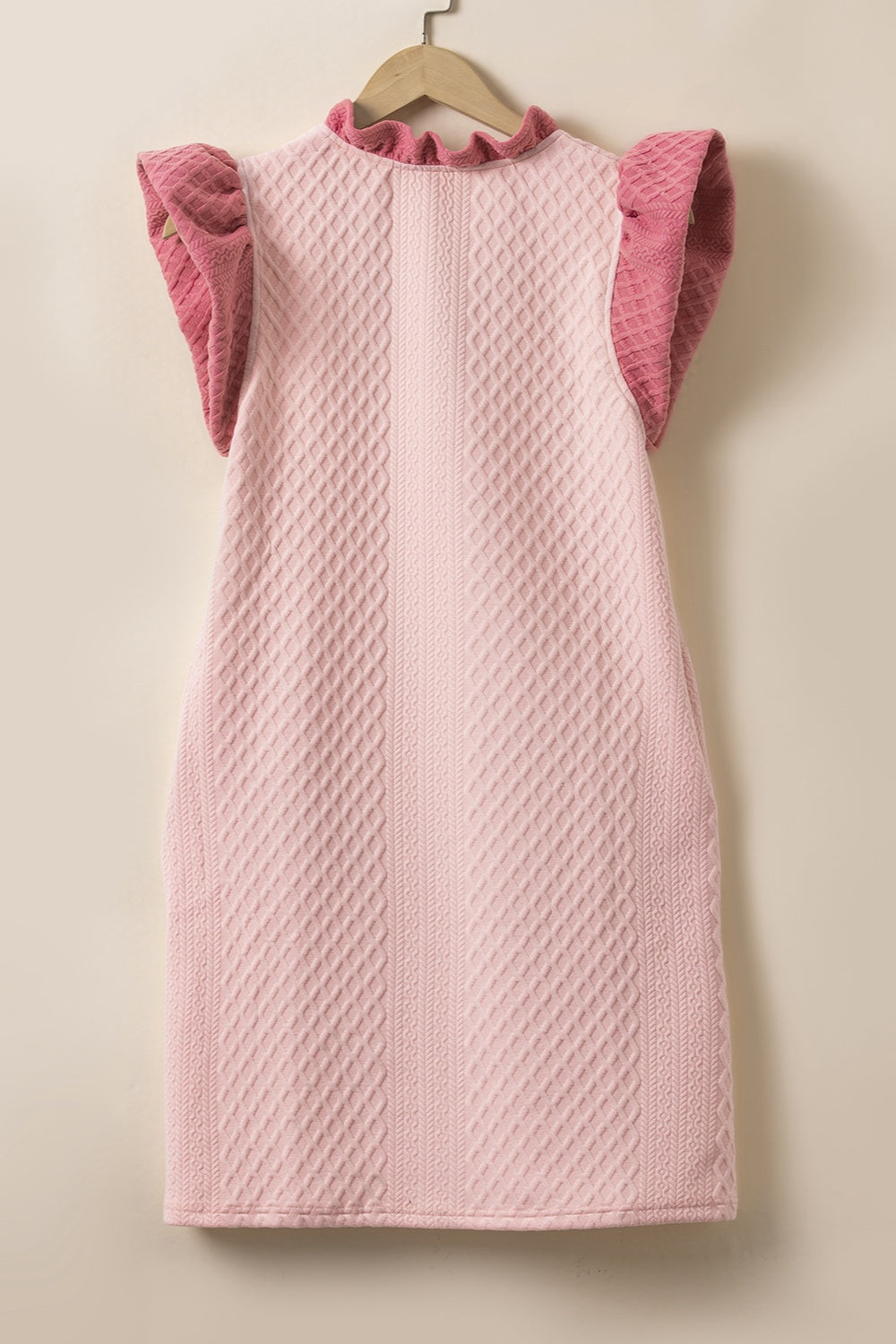 Blush pink trapeze dress with textured diamond pattern, ruffle neckline and short ruffle sleeves.
