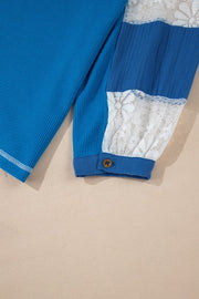 Blue waffle knit top with white lace paneled sleeves and button cuff detail.