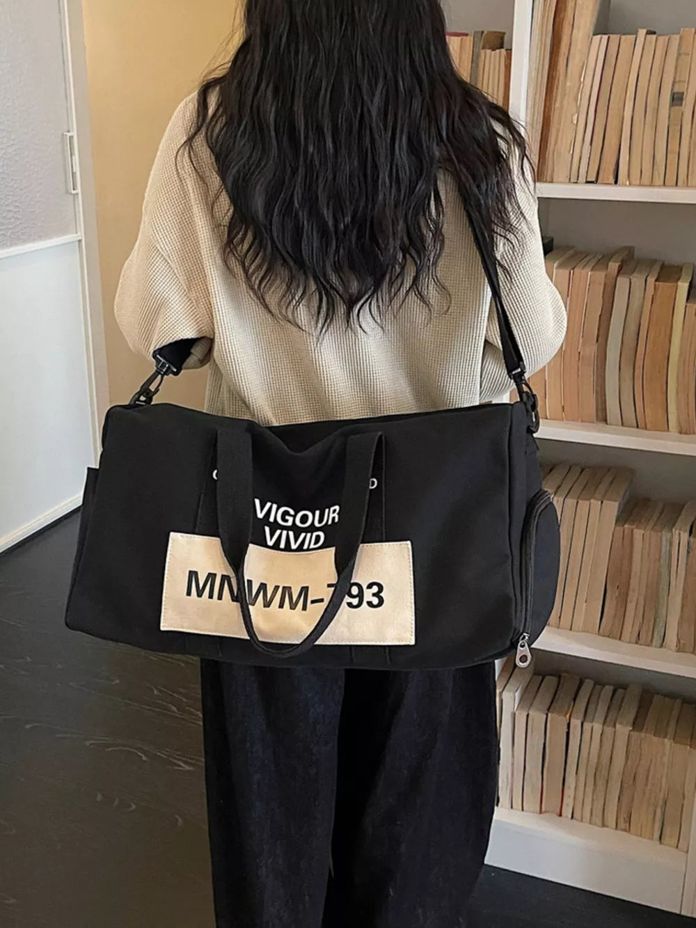 Black nylon travel bag with VIGOUR VIVID graphic print and adjustable strap.