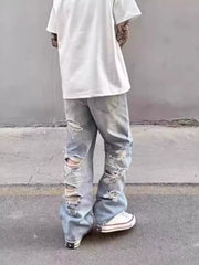 Relaxed fit light wash wide leg jeans with heavy distressing and rips.