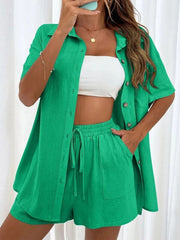 Green linen shirt and shorts set with button front and drawstring waist.