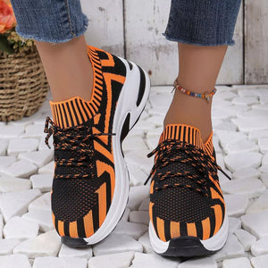 Orange and black geometric knit platform sneakers with white soles and black laces.