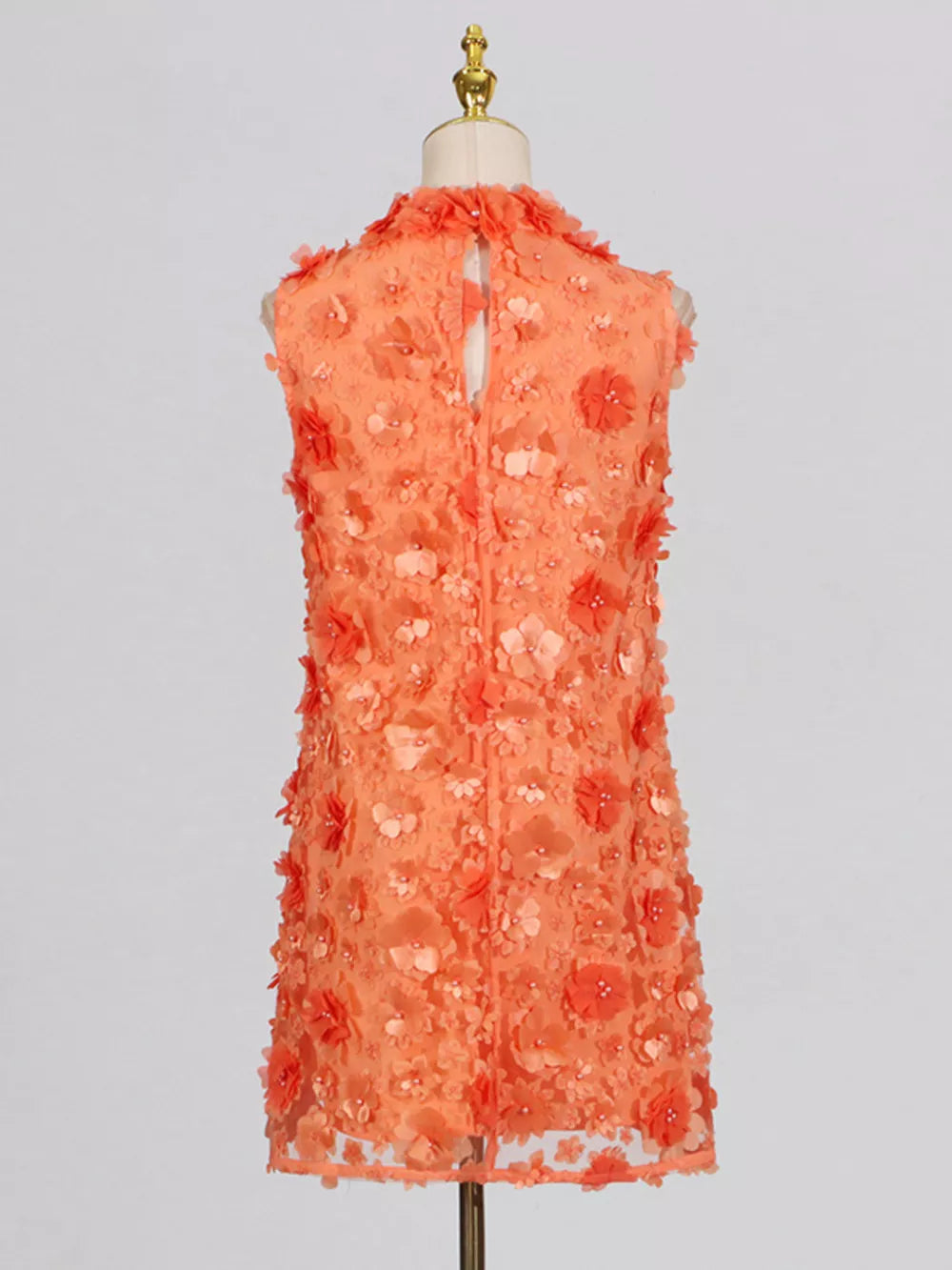 Orange floral applique mini dress with ruffled neckline and buttoned back detail.