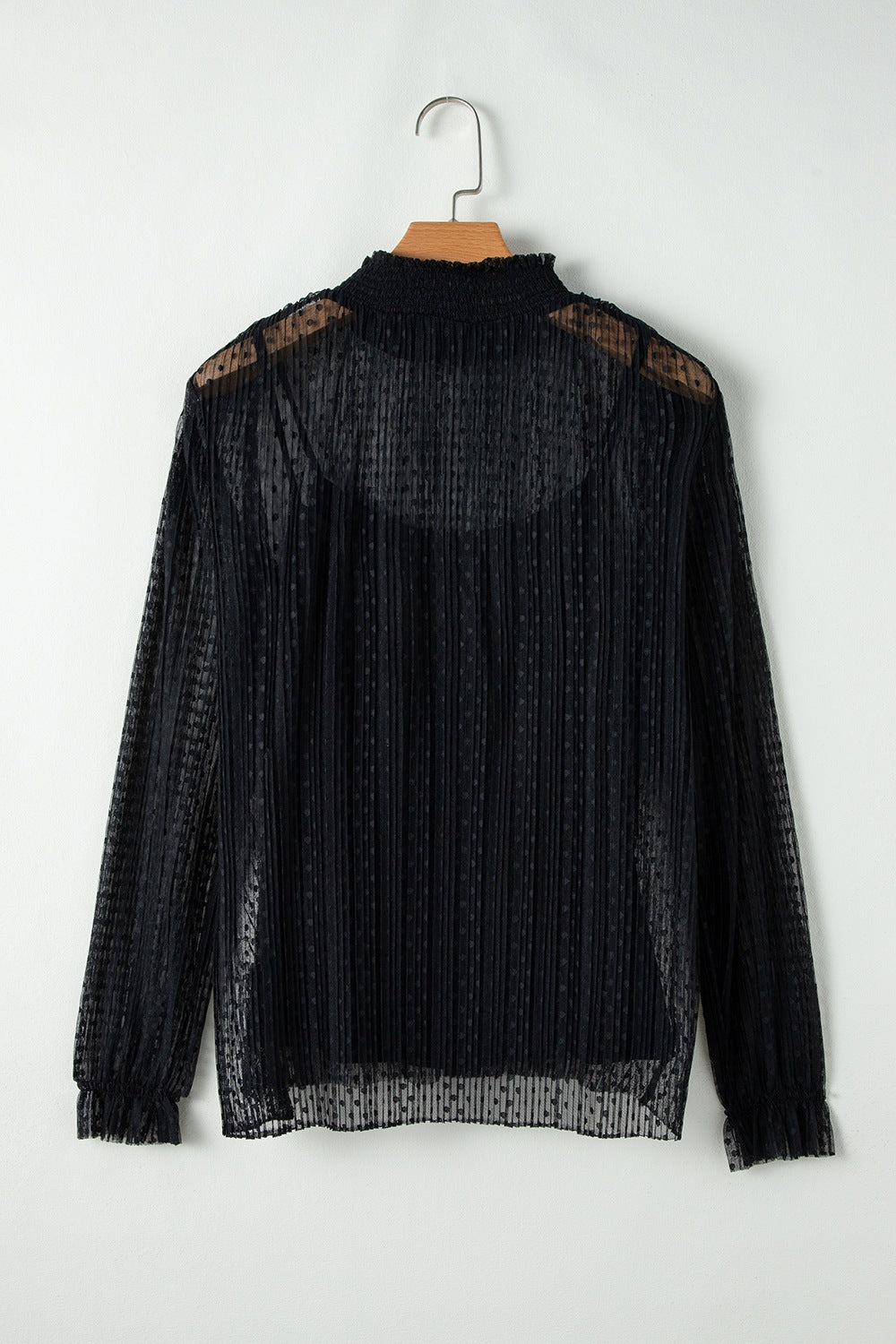Black sheer mock neck blouse with textured dots and vertical pleats.