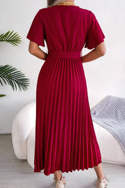 Red wrap bodice pleated midi dress with flutter sleeves and belted waist.