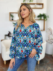 Prismatic ikat blouse with voluminous sleeves in blue and green, featuring a V-neck and relaxed fit.