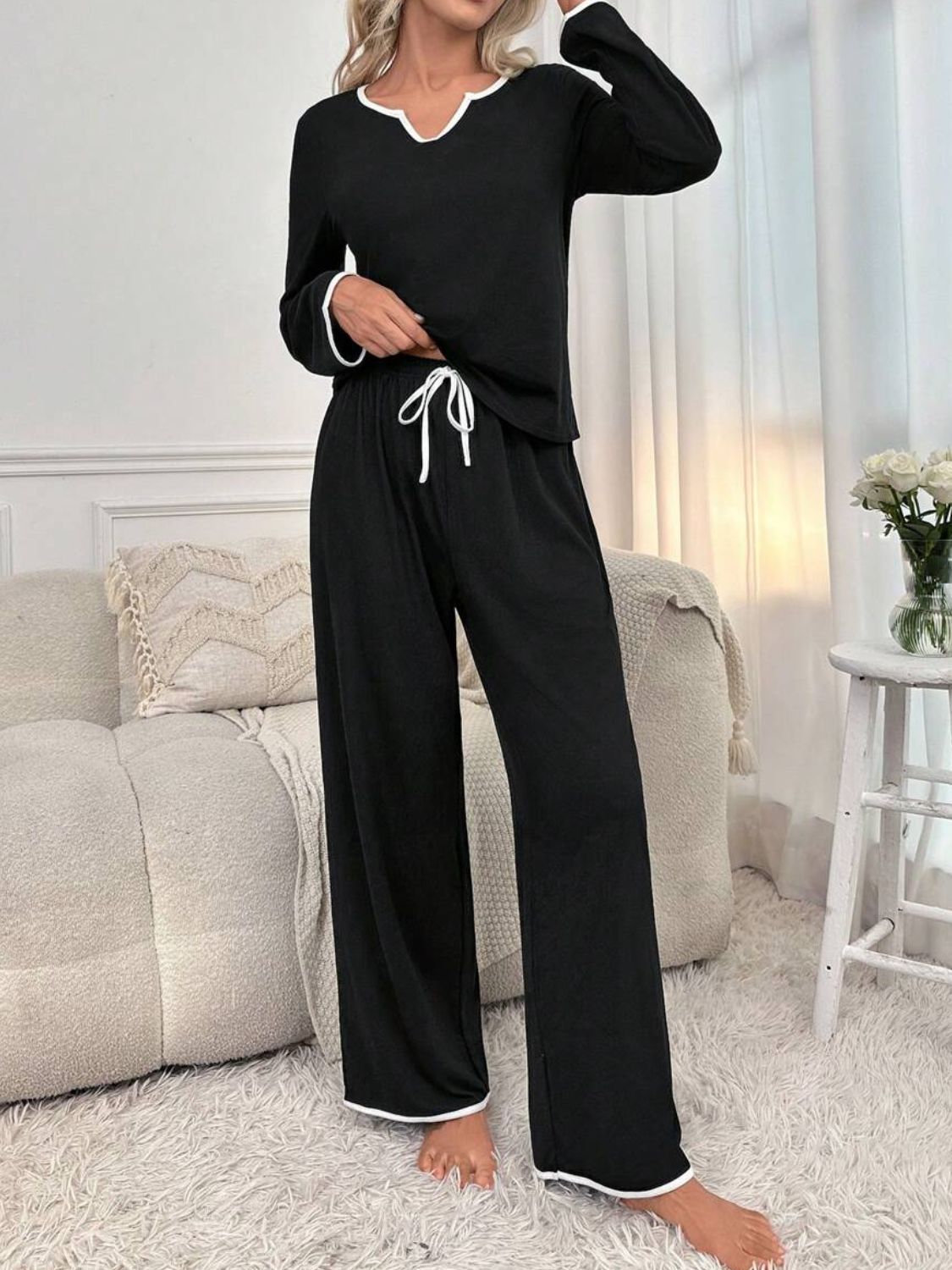 Black loungewear set with contrast trim, V-neck top and wide-leg pants.