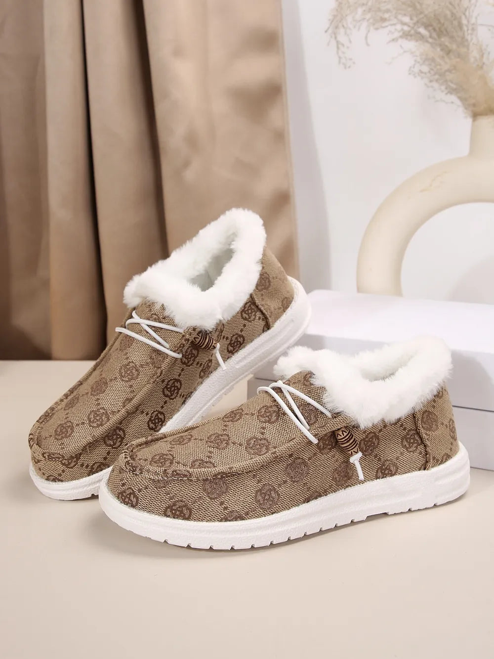 Taupe Southwestern print faux fur lined loafers with white laces and white soles.