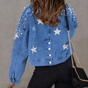 Light denim jacket with pearl and star embellishments, buttoned front, and distressed details.