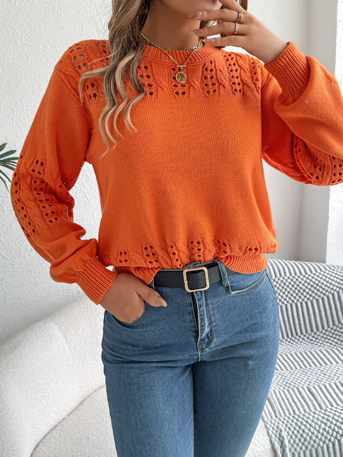 Orange openwork knit sweater with detailed sleeves and neckline, crew neck, long sleeves.