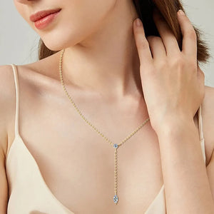 Gold lariat necklace with marquise moissanite pendant and chain detail.