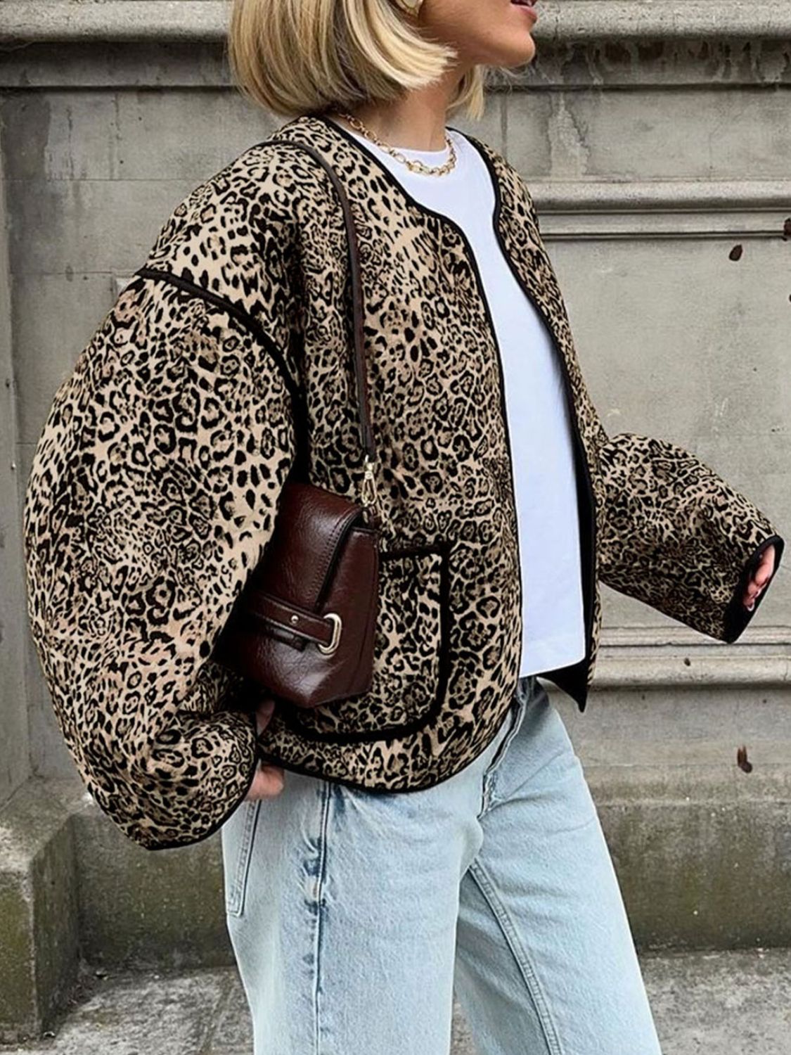 Leopard print boxy jacket with black trim and pockets, worn open over a white tee.
