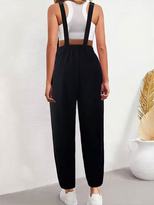 Black corduroy overalls with adjustable straps and a relaxed fit, styled with a white crop top.