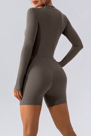 Sculpted performance romper in Caramel with zip detail, long sleeves, and short legs.