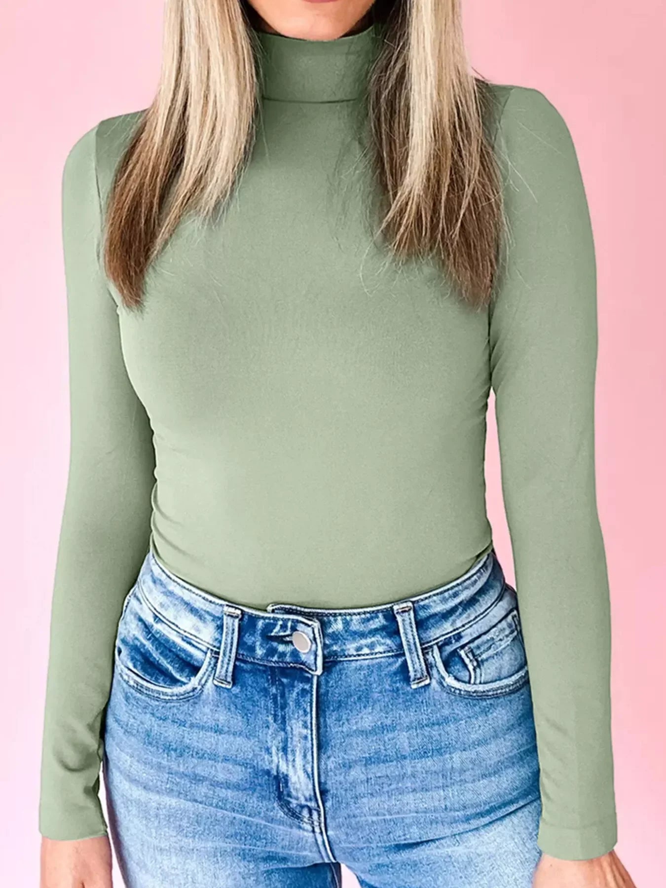 Stretchy long-sleeve turtleneck tunic in sage green, styled with blue jeans.