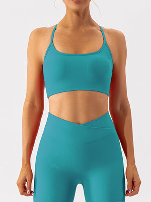 Teal ribbed halterneck active bra with scoop neckline and thin straps.