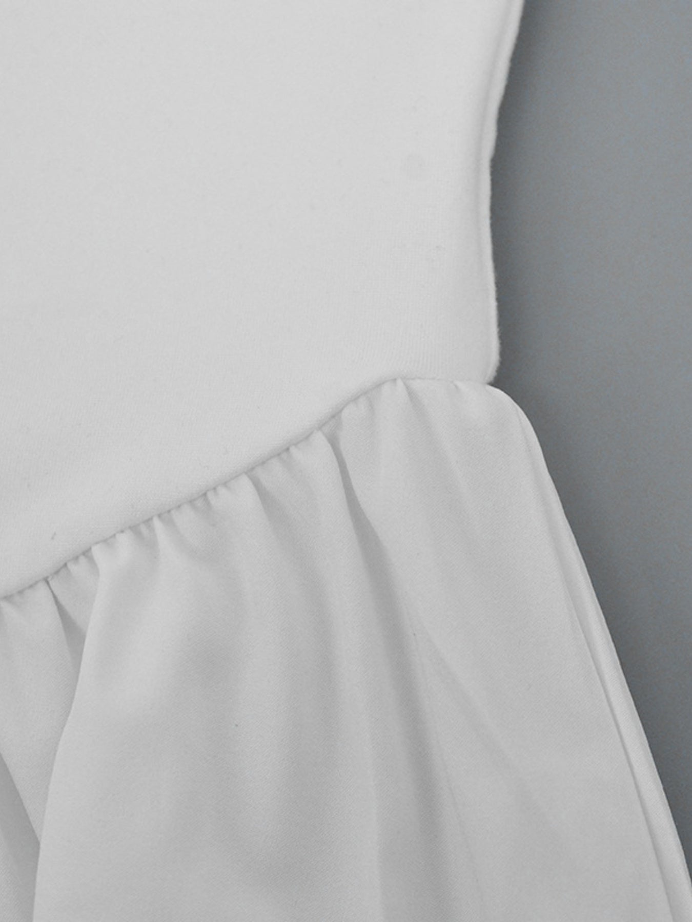 White flowy maxi dress with gathered ruffle detail at the waist.