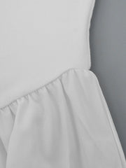 White flowy maxi dress with gathered ruffle detail at the waist.