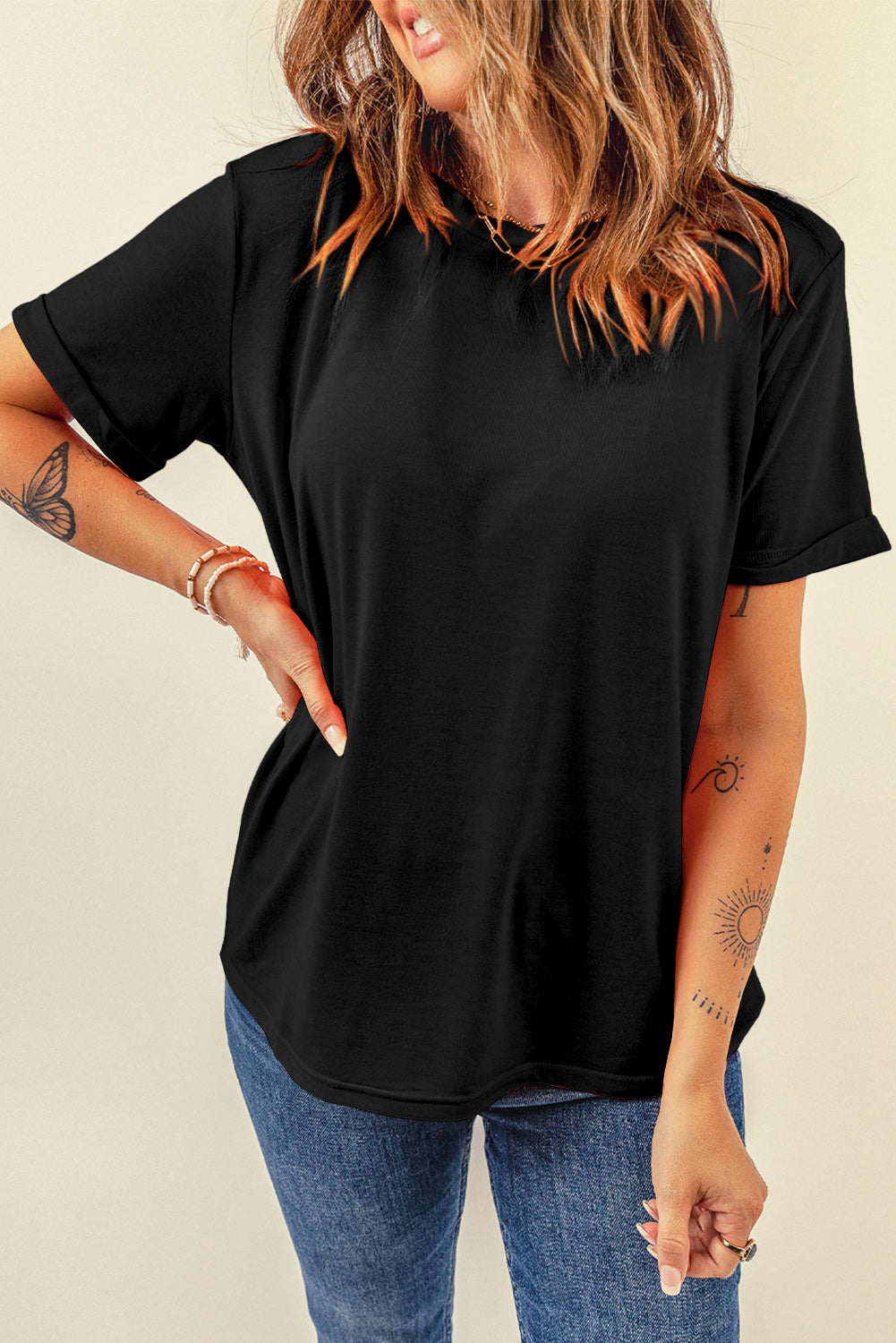 Black rolled sleeve raglan tee with a relaxed fit, styled with jeans.