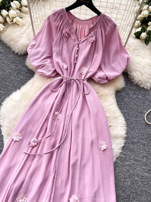 Purple floral maxi dress with puff sleeves, tie waist, and button front.