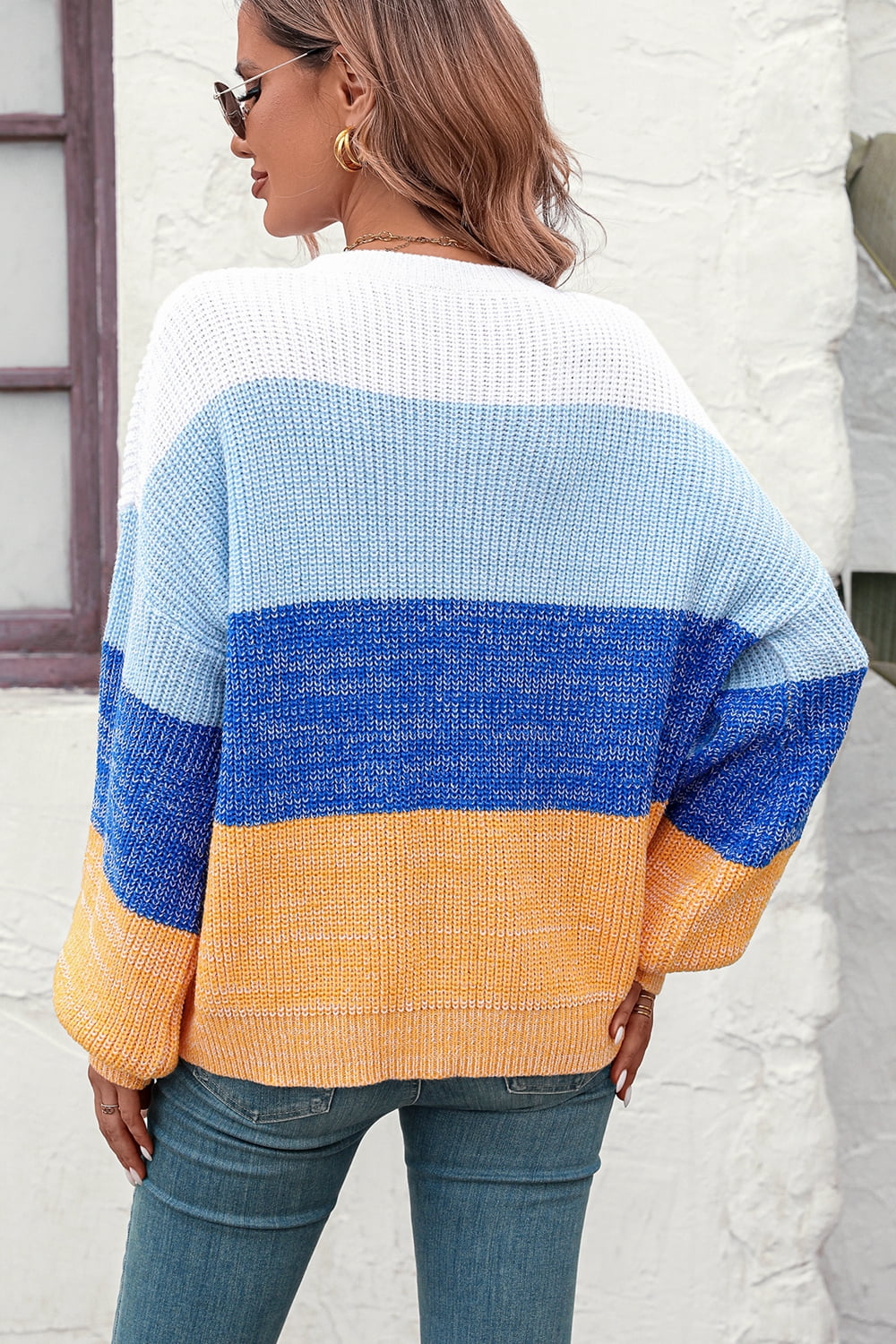 Ombre ribbed knit sweater with balloon sleeves in blue, white, and orange stripes.