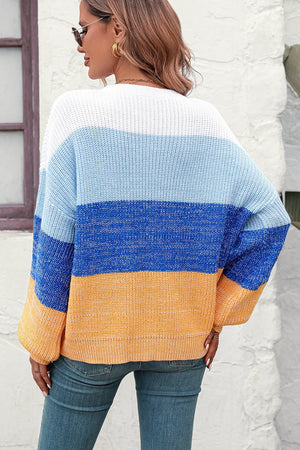 Ombre ribbed knit sweater with balloon sleeves in blue, white, and orange stripes.