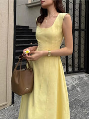 Sleeveless yellow midi dress with square neckline and a-line skirt.