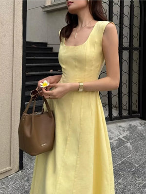Sleeveless yellow midi dress with square neckline and a-line skirt.