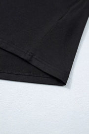 Black tie-wrap two-piece ensemble detail showing hem stitching