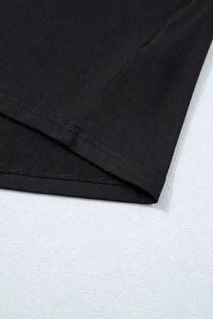 Black tie-wrap two-piece ensemble detail showing hem stitching