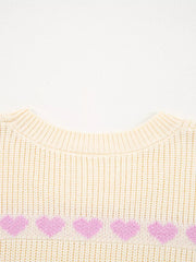 Cream knit sweater with a row of pink hearts across the chest.