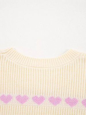 Cream knit sweater with a row of pink hearts across the chest.