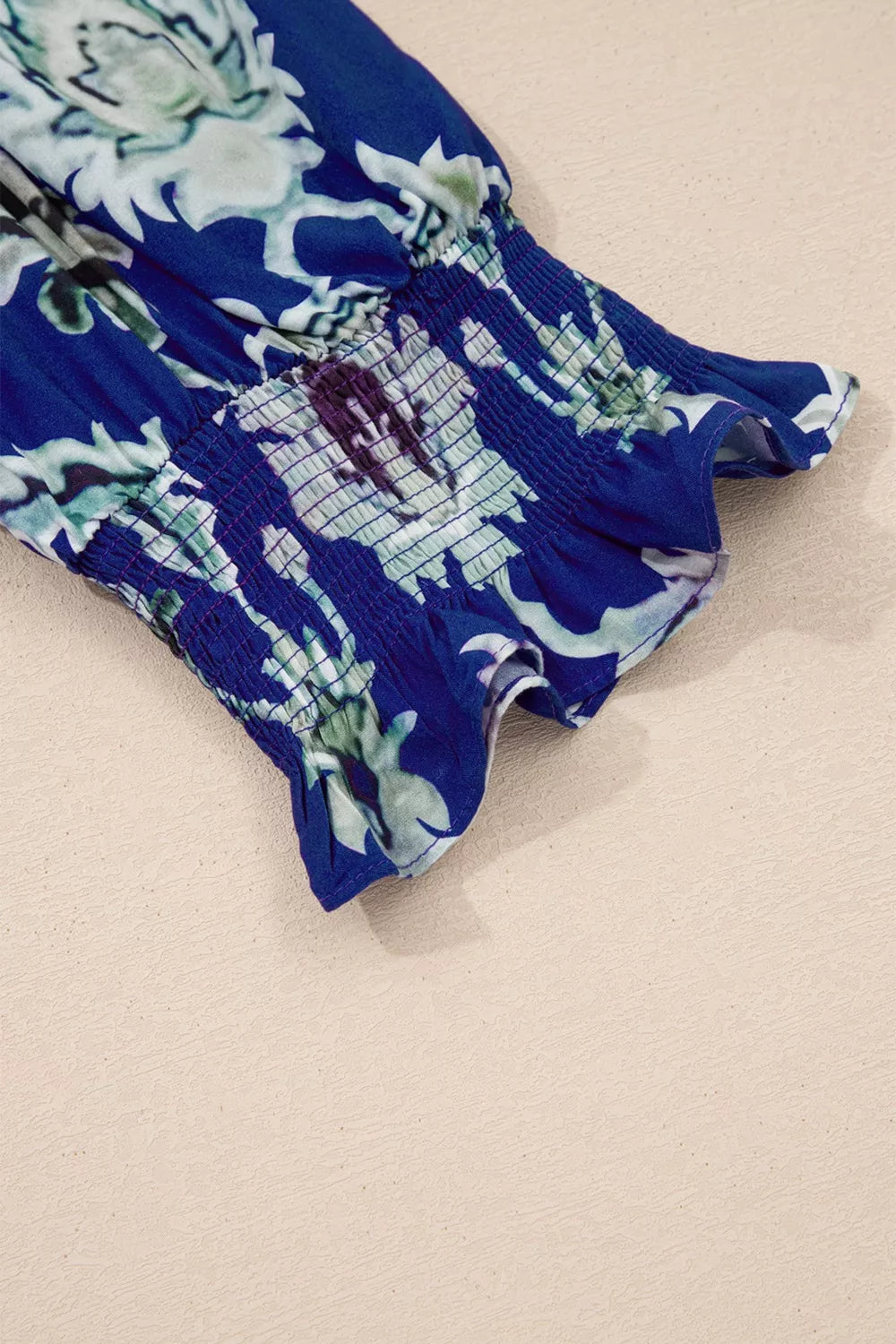 Vibrant floral maxi dress with smocked cuffs and frilled hem detail.