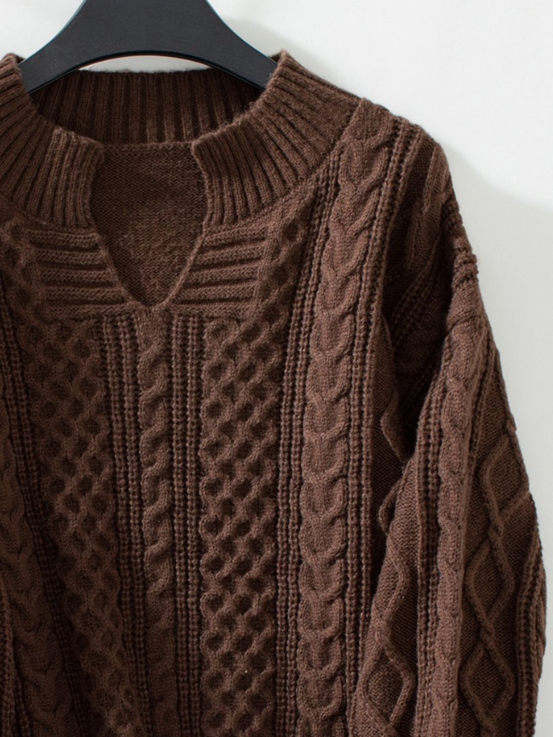 Chocolate cable knit sweater with keyhole neckline and ribbed cuffs.