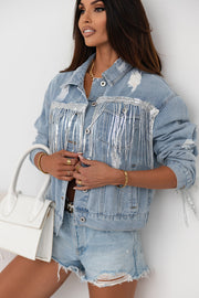 Medium wash denim trucker jacket with sequin fringe and distressed details.