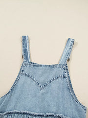 Tiered denim overall dress in light blue with adjustable straps and frayed hem detail.