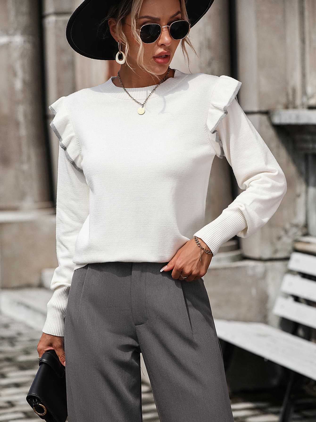 White crew neck sweater with contrast trim ruffle shoulders and long sleeves.