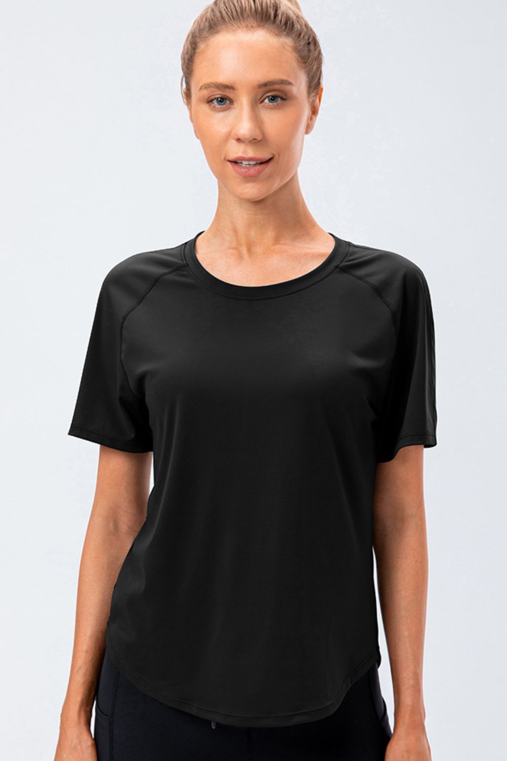 Black performance raglan crew neck tee with short sleeves and curved hem