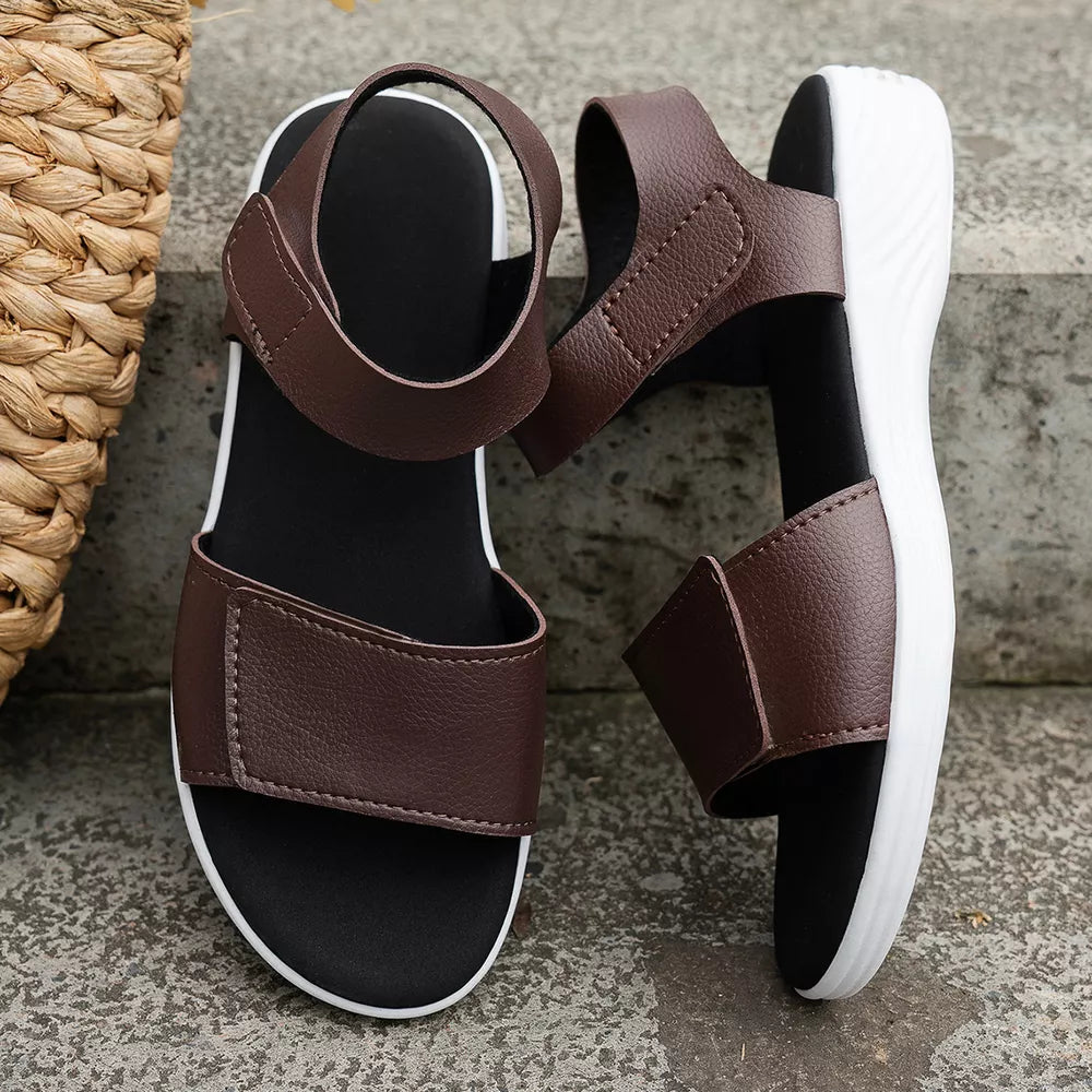 Brown adjustable open-toe platform sandals with chunky white soles and velcro straps.
