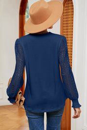 Dark blue knit top with lace sleeves and ruffled cuffs.