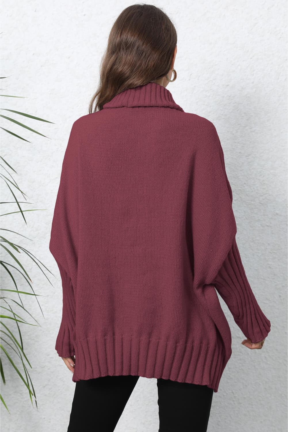 Burgundy ribbed knit turtleneck sweater with batwing sleeves and ribbed cuffs.
