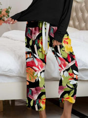 Botanical print lounge pants with white tie waist and black top.