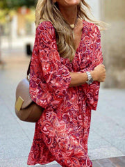 Red paisley print dress with balloon sleeves and a V-neck, styled with a brown crossbody bag.